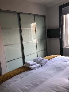 a bed with two towels sitting on top of it at reflections luxury modern accommodation in Saint Monance