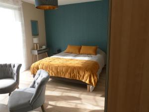 a bedroom with a bed and a green wall at Le Clos de l'Abré in Gatteville-le-Phare