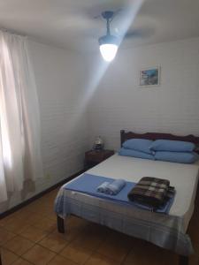 a bedroom with a bed with blue pillows at Sobrado de Caiobá in Matinhos +21 photos