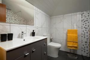 a bathroom with a sink and a toilet and a mirror at Martinho Apartment View in Arco da Calheta