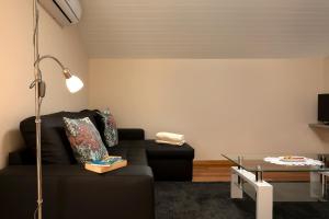 uma sala de estar com um sofá preto e uma mesa de vidro em Martinho Apartment View em Arco da Calheta