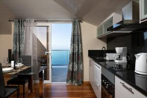 a kitchen with a table and a view of the ocean at Martinho Apartment View in Arco da Calheta