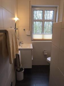 a bathroom with a sink and a window at Huus-Windroos in Ditzum