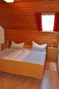 ein Schlafzimmer mit einem Bett in einer Holzwand in der Unterkunft Hinterkimmighof in Oberharmersbach