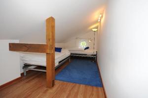 ガルミッシュ・パルテンキルヒェンにあるFerienwohnung-Am-Kurpark-Wohnung-3-150qmの二段ベッド2台と青いラグが備わる客室です。