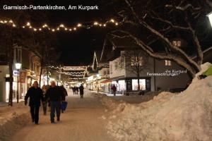 ガルミッシュ・パルテンキルヒェンにあるFerienwohnung-Am-Kurpark-Wohnung-3-150qmの雪の中を歩く人々