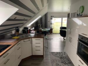 a kitchen with white cabinets and a table in a room at Haus-Encore-Wohnung-4 in Büsum +7 photos