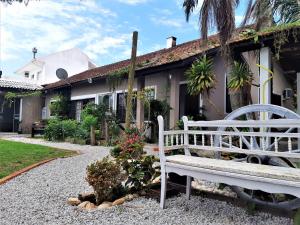 un banco blanco sentado frente a una casa en Estaleiro das Artes., en Florianópolis