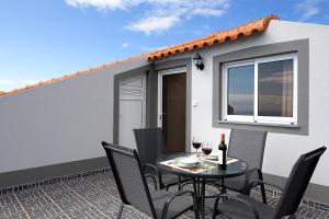a patio with a table and chairs and a building at Martinho Apartment View in Arco da Calheta +12 photos