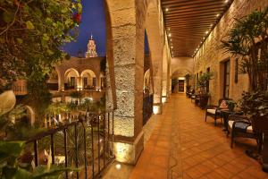 a hallway in a building with tables and chairs at Hotel De La Soledad in Morelia
