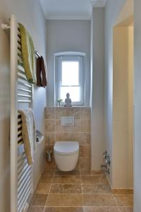 ein kleines Bad mit einem WC und einem Fenster in der Unterkunft App. 8 in strandnaher Lage - Bäderstil-Villa in Wenningstedt/Sylt in Wenningstedt-Braderup