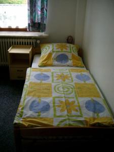 ビューズムにあるFerienhaus-ANNE-FW-4のベッドルーム1室(黄色と青のキルトのベッド1台付)