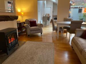 a living room with a fireplace and a table and chairs at Stable Cottage Lytham in Lytham St Annes