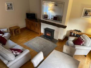 a living room with two couches and a fireplace at Stable Cottage Lytham in Lytham St Annes