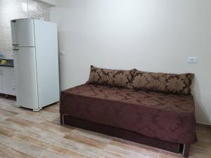 a couch in a room with a refrigerator at Recanto da Serra Chalé 01 in Mauá da Serra