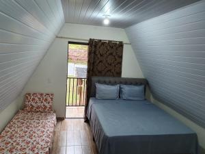 Un pat sau paturi într-o cameră la Recanto da Serra Chalé 01