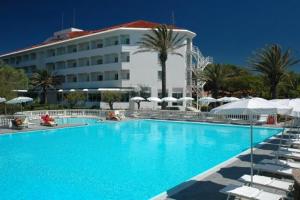 une grande piscine bleue en face d'un hôtel dans l'établissement Domizia Palace Hotel, à Baia Domizia