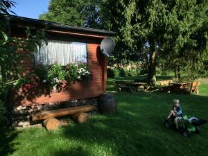 a child sitting in front of a tiny house at Bungalow in Hermsdorf