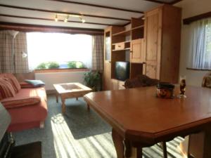 Bungalow في Hermsdorf: غرفة معيشة مع طاولة وأريكة