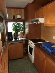 a kitchen with wooden cabinets and a stove top oven at Bungalow in Hermsdorf