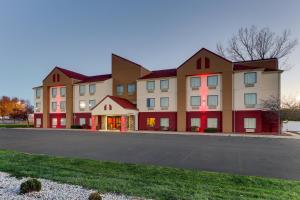 a large apartment building with red doors on a street at Red Roof Inn Springfield, OH in Springfield