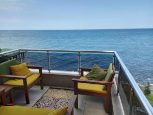 ein Balkon mit Stühlen und Blick auf das Meer in der Unterkunft Trabzon Seaside in Trabzon