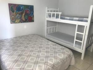 Un dormitorio con dos literas y un cuadro. en Sobrado 03 na Praia de Bombas, en Bombinhas