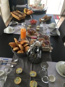 una mesa cubierta con un tazón de pan y zumo de naranja en Le Clos de l'Abré, en Gatteville-le-Phare