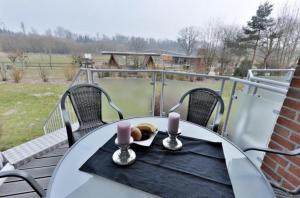 einen Tisch mit zwei Kerzen und einem Teller Essen auf dem Balkon in der Unterkunft Appartement 27a - Sandburg - mit Zugang zum Garten in Timmendorfer Strand