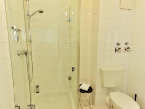 ein weißes Bad mit einer Dusche und einem WC in der Unterkunft Appartement 35 - Ostseehafen in Timmendorfer Strand
