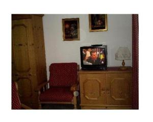 a living room with a tv and a chair at Haus-Alphorn-Wohnung-15 in Oberstdorf