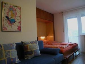 um quarto com uma cama, um sofá azul e uma cama em Falkenhorst-Wohnung-40 em Oberstdorf