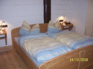 una cama de madera con almohadas en una habitación en Sport-Alpin-Wohnung-10, en Oberstdorf