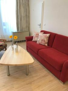 ein Wohnzimmer mit einem roten Sofa und einem Couchtisch in der Unterkunft Sport Alpin Wohnung 4 in Oberstdorf