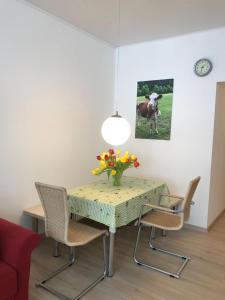 ein Esszimmer mit einem Tisch und Stühlen mit einer Blumenvase in der Unterkunft Sport Alpin Wohnung 4 in Oberstdorf