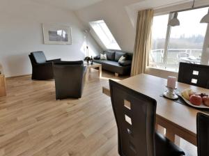 ein Wohnzimmer mit einem Tisch, Stühlen und einem Sofa in der Unterkunft Appartement 36 - Ostseeglück in Timmendorfer Strand