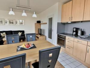 eine Küche und ein Wohnzimmer mit einem Tisch und einer Obstschale in der Unterkunft Appartement 33 - Ostseeluft in Timmendorfer Strand