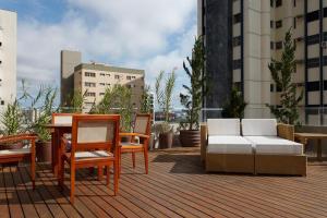 a patio with furniture and a table and chairs at Oft Alfre hotels - Goiânia in Goiânia