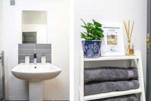 a white bathroom with a sink and a mirror at The Penthouses, 8 Albion Mews in Chester