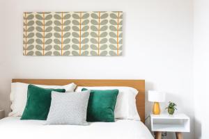 a bedroom with a bed with green and white pillows at The Penthouses, 8 Albion Mews in Chester