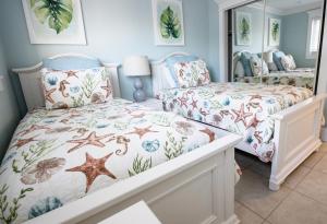 a bedroom with two beds and a mirror at Anna Maria Island Inn in Bradenton Beach