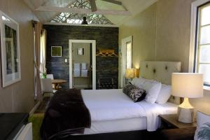 ein Schlafzimmer mit einem weißen Bett und einer Ziegelwand in der Unterkunft The Laurels of Chinchilla in Chinchilla