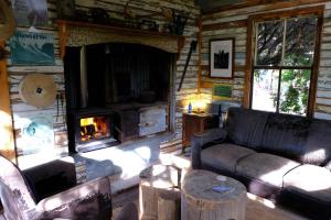 a living room with a fireplace in a log cabin at The Laurels of Chinchilla in Chinchilla