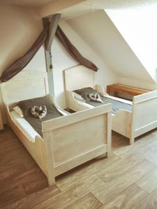 two beds in a room with a attic at Turmblick-Gaestequartier-Coswig-Hier-erwartet-Sie-individueller-Service-im-Herzen-der-Altstadt in Coswig