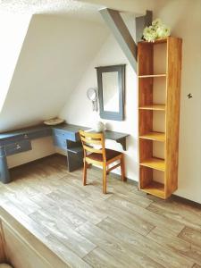 um quarto no sótão com uma secretária e uma cadeira em Turmblick-Gaestequartier-Coswig-Hier-erwartet-Sie-individueller-Service-im-Herzen-der-Altstadt em Coswig