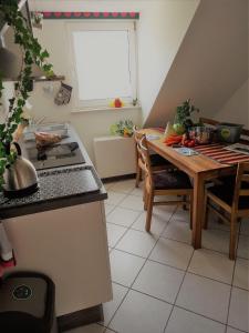 kuchnia ze stołem, kuchenką i oknem w obiekcie Turmblick-Gaestequartier-Coswig-Hier-erwartet-Sie-individueller-Service-im-Herzen-der-Altstadt w mieście Coswig