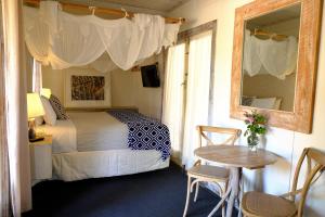 a bedroom with a bed and a table and a mirror at The Laurels of Chinchilla in Chinchilla