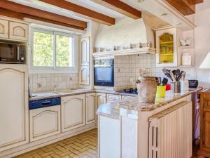 a kitchen with white cabinets and a sink at Holiday home in Brittany near the sea in Pénestin