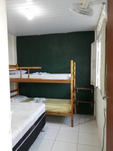 2 literas en una habitación con una pared verde en Casa acolhedora - aluguel por temporada, en Lençóis