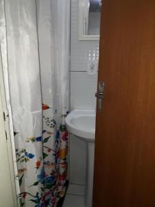 a bathroom with a sink and a toilet and a shower curtain at Casa acolhedora - aluguel por temporada in Lençóis +28 photos